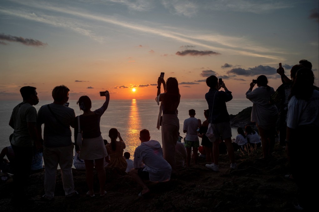 Locals and tourists watch a sunset from Phuket Island’s Phromthep Cape in Thailand. The Thai central bank’s struggle to deal with inflation while sustaining economic growth could signal to currency markets that the baht is somewhat exposed. Photo: Reuters