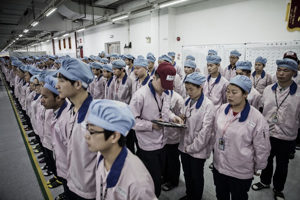 A supervisor holds an iPad as he checks an employee’s badge during roll call at a Pegatron factory in Shanghai. The company has suspended production in Shanghai and nearby Kunshan due to Covid-19 lockdowns. Photo: Bloomberg