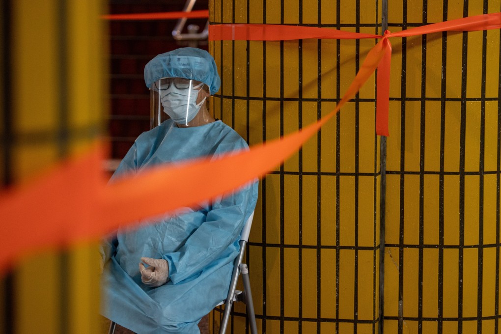 A health worker sits outside a building under lockdown on March 25. Frontline Covid-19 staff are experiencing burnout amid Hong Kong’s deadly fifth wave. Photo: EPA-EFE