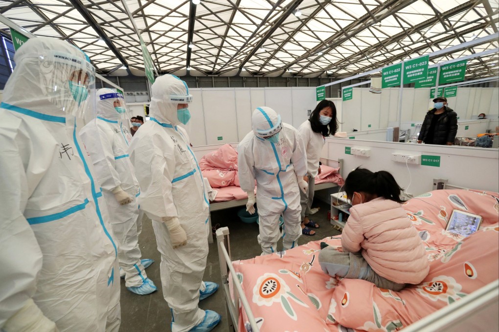 Medical workers in protective suits check on a child patient as they conduct ward rounds at Shanghai New International Exhibition Hall, which has been turned into a makeshift Covid-19 hospital in Shanghai. Photo: Reuters