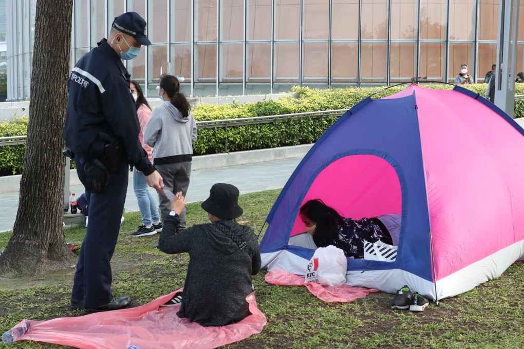 A police officer reminds people to comply with social-distancing rules. Photo: Edmond So