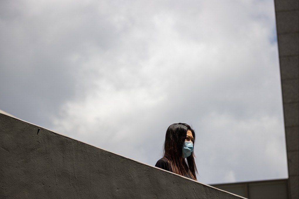A woman wears a face mask as she walks down a flight of stairs in Central, Hong Kong, on Monday. Photo: EPA-EFE
