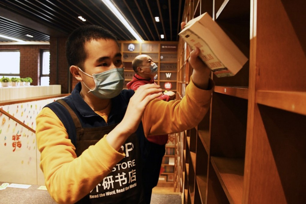 Kang Rui (L) arranges books with his colleagues at FLTRP Bookstore in Beijing. Photo: Xinhua