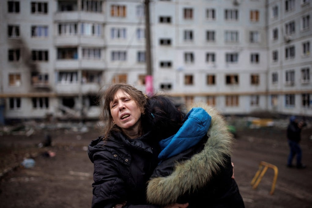 A woman reacts as she hugs another woman outside a heavily damaged apartment block, following an artillery attack, amid Russia’s attack on Ukraine, in Kharkiv on April 13, 2022. Photo: Reuters