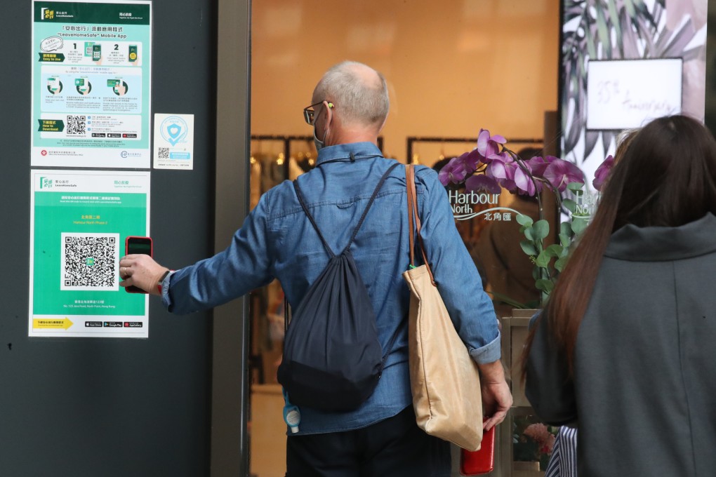 A man scans a “Leave Home Safe” QR code before entering a  shopping mall on April 7. Photo: Edmond So
