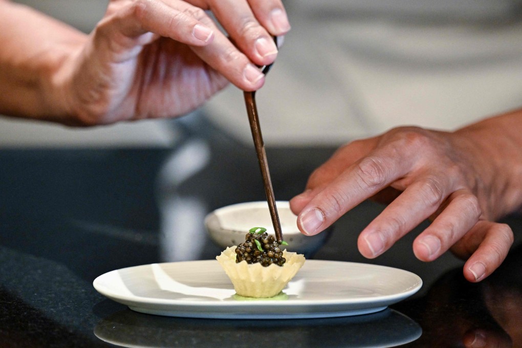 Chef Thitid “Ton” Tassanakajohn makes a dish using caviar from Thai Sturgeon Farm at his Lahnyai Nusara restaurant in Bangkok. Photo: AFP