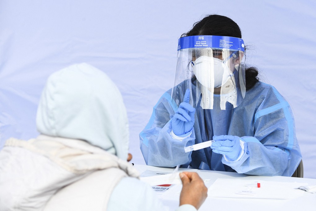 A health worker gives instructions to a person on how to carry out a Covid-19 swab test. Photo:  AFP via Getty Images/TNS