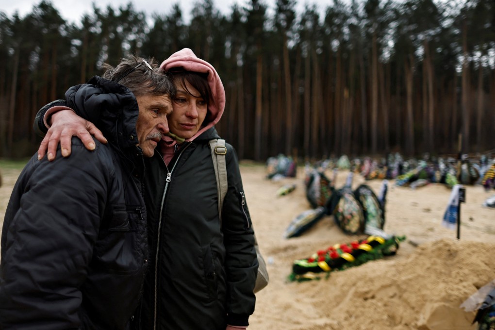 Two Ukrainians mourn a relative who according to his family was killed by Russian soldiers. Photo: Reuters