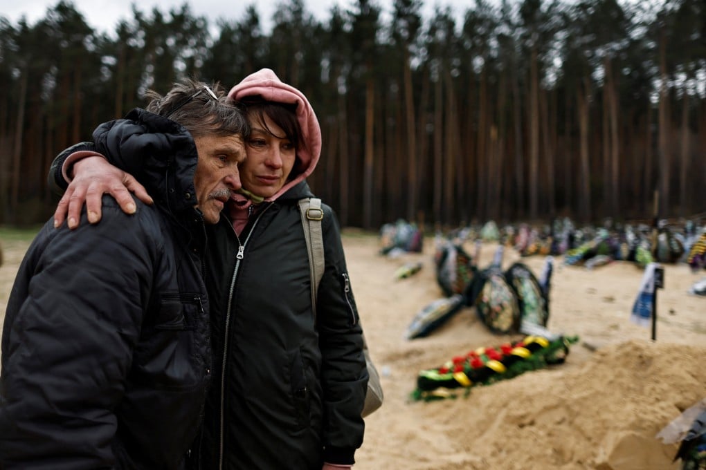 Two Ukrainians mourn a relative who according to his family was killed by Russian soldiers. Photo: Reuters
