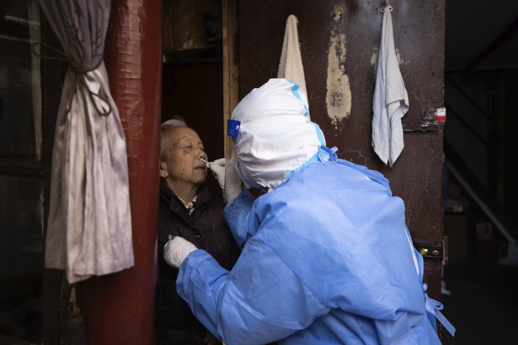 A medical worker conducts antigen testing for an elderly resident in Shanghai on Sunday, April 3, 2022. Photo: Xinhua via AP