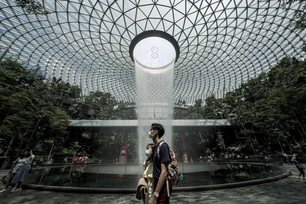 A couple walks past the Rain Vortex waterfall at the Jewel Changi airport mall in Singapore. The city state will soon eliminate Covid tests for vaccinated travellers. Photo: EPA-EFE