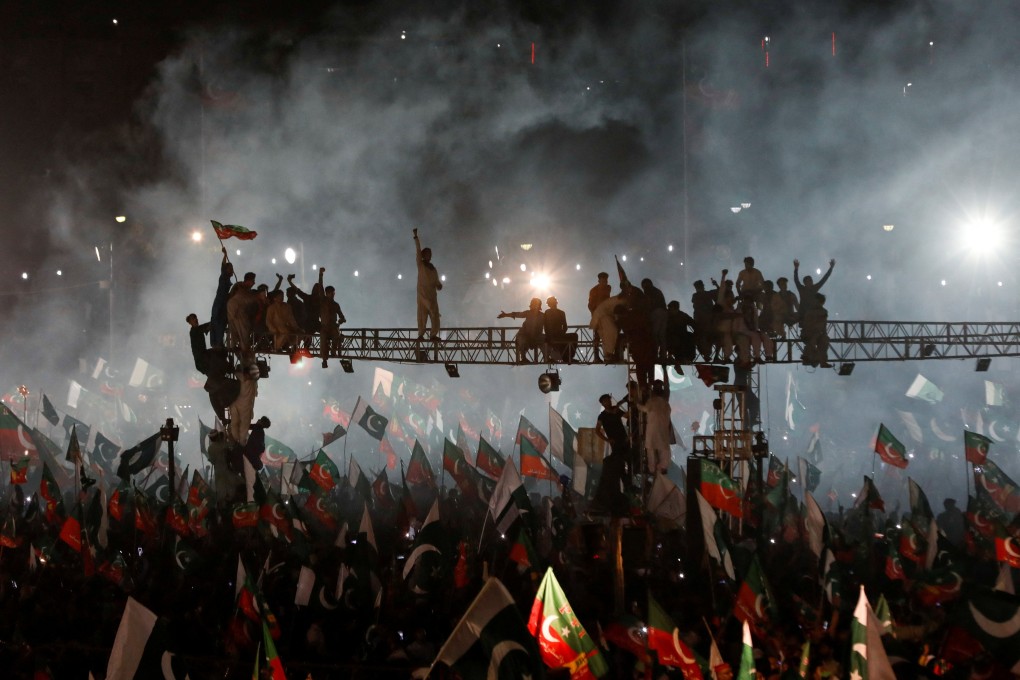 Supporters of Imran Khan’s Pakistan Tehreek-e-Insaf (PTI) political party listen to the ousted prime minister speak at a rally in Karachi on April 16. Photo: Reuters