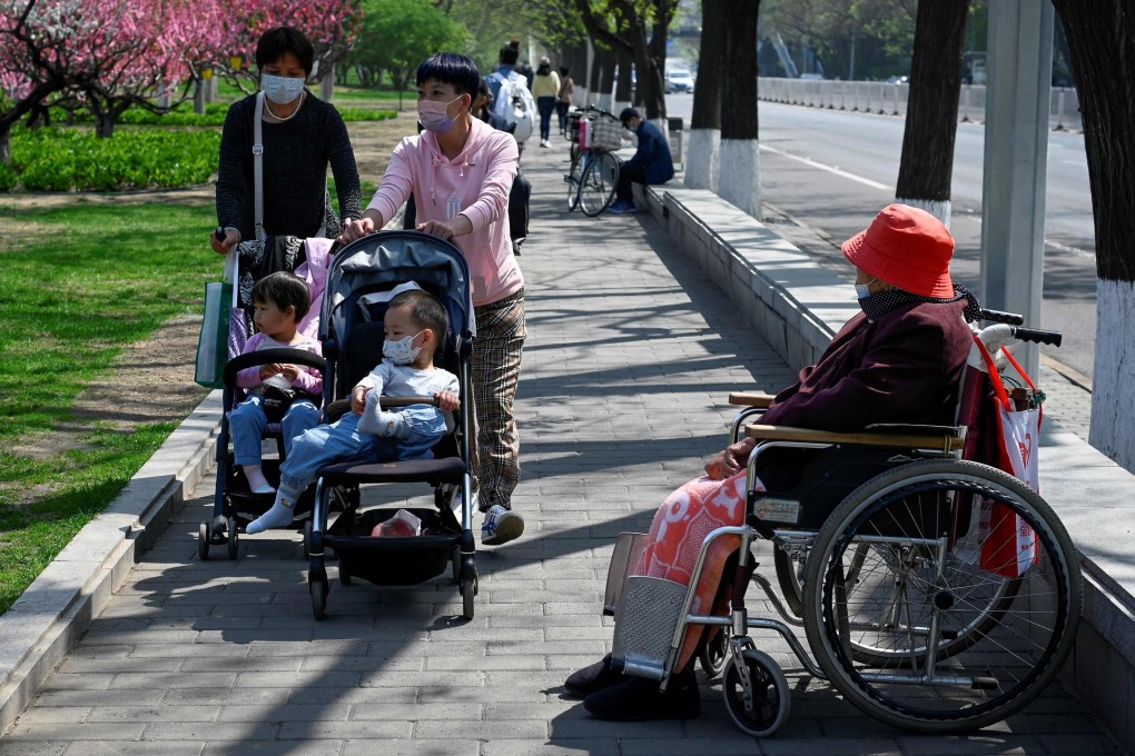 Two women push strollers past an elderly woman in Beijing on April 19. The growing number of elderly in China will create a far-reaching financial burden on local governments. Photo: AFP