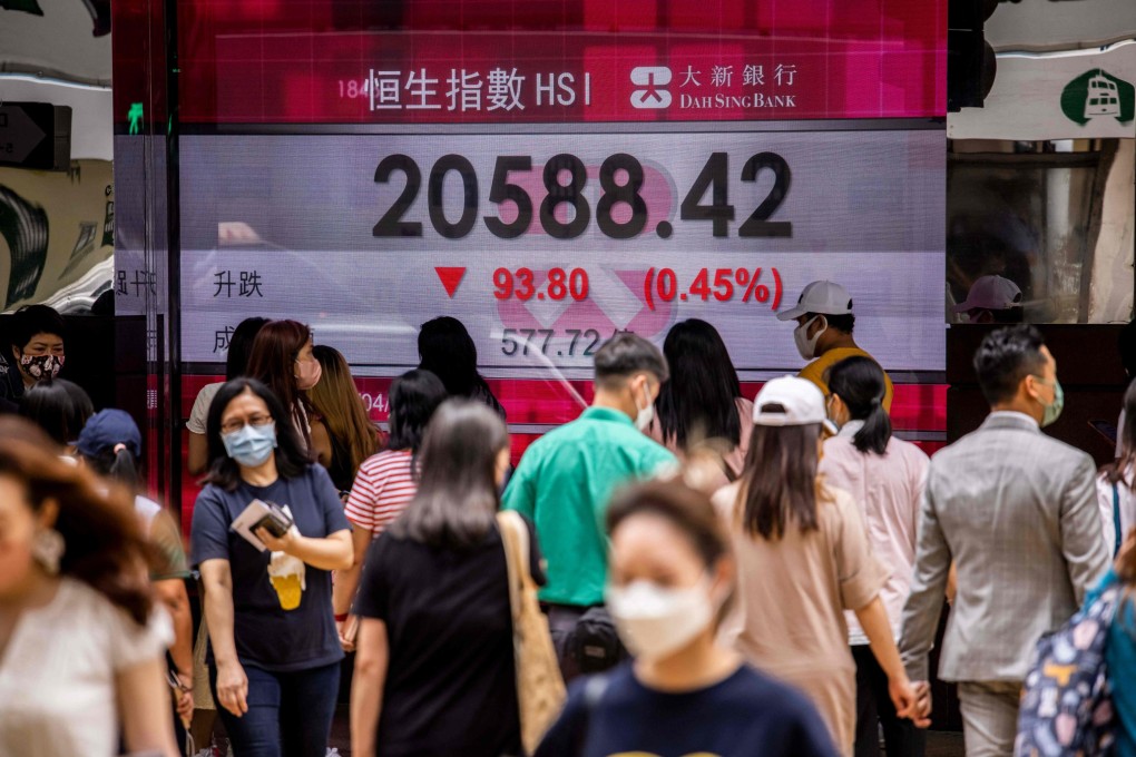 People walk past an electronic board showing the Hang Seng Index in Hong Kong on April 22. Photo: AFP