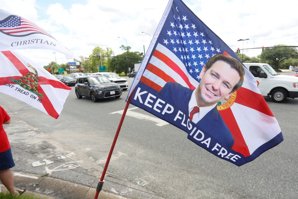 A flag with a photo of Florida Governor Ron DeSantis is seen as protesters gather for a rally outside Walt Disney World in Orlando, Florida, on April 16. Photo: Reuters