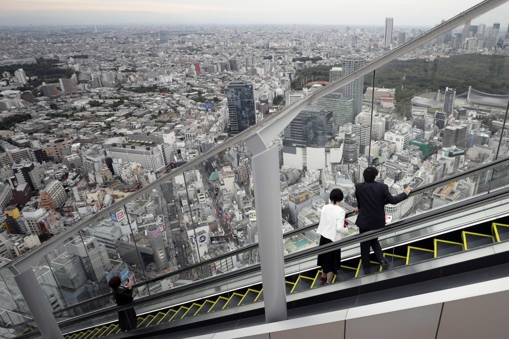 Visitors look at the view while riding on an escalator at the Shibuya Sky observation deck of the Shibuya Scramble Square building in Tokyo. Photo: Bloomberg