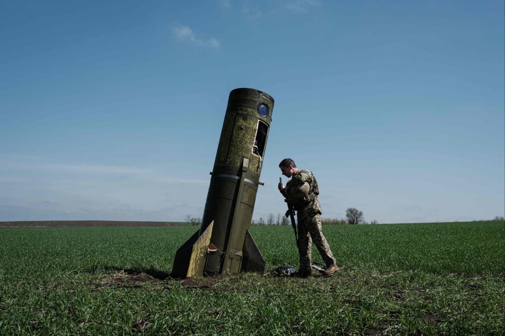 A Ukrainian serviceman inspects a part of a Russian ballistic missile booster that fell in a field in Bohodarove, eastern Ukraine. Photo: AFP