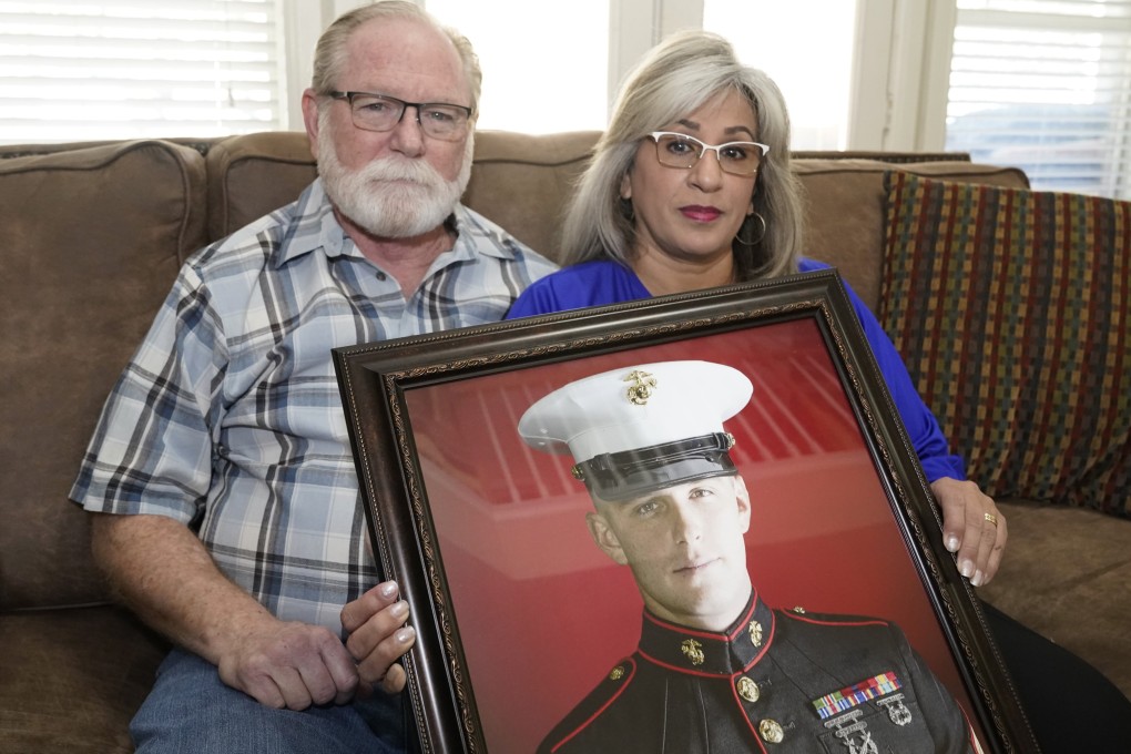 Russian prisoner Trevor Reed’s parents Joey and Paula Reed pose for a photo with his portrait at their home in Fort Worth, Texas, in February. Photo: AP