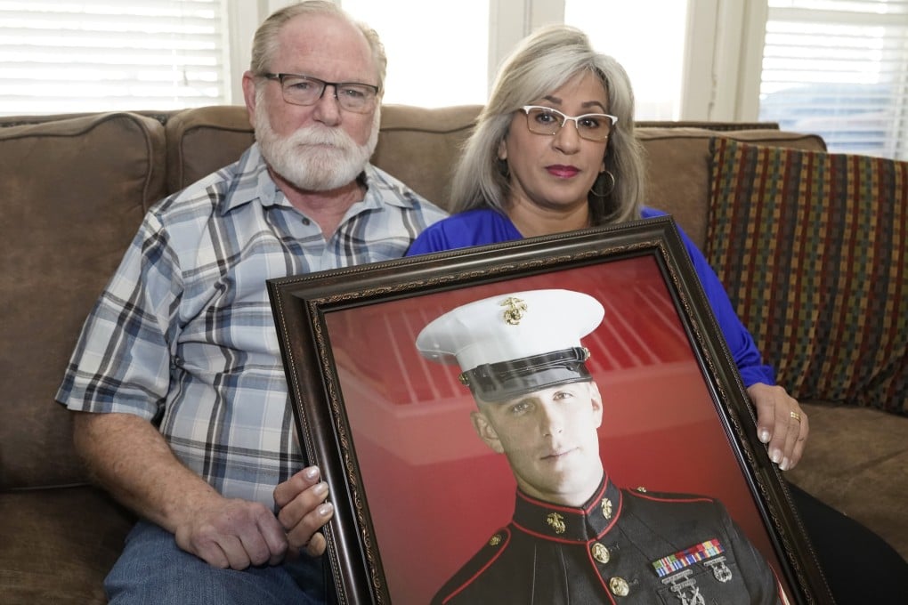 Russian prisoner Trevor Reed’s parents Joey and Paula Reed pose for a photo with his portrait at their home in Fort Worth, Texas, in February. Photo: AP