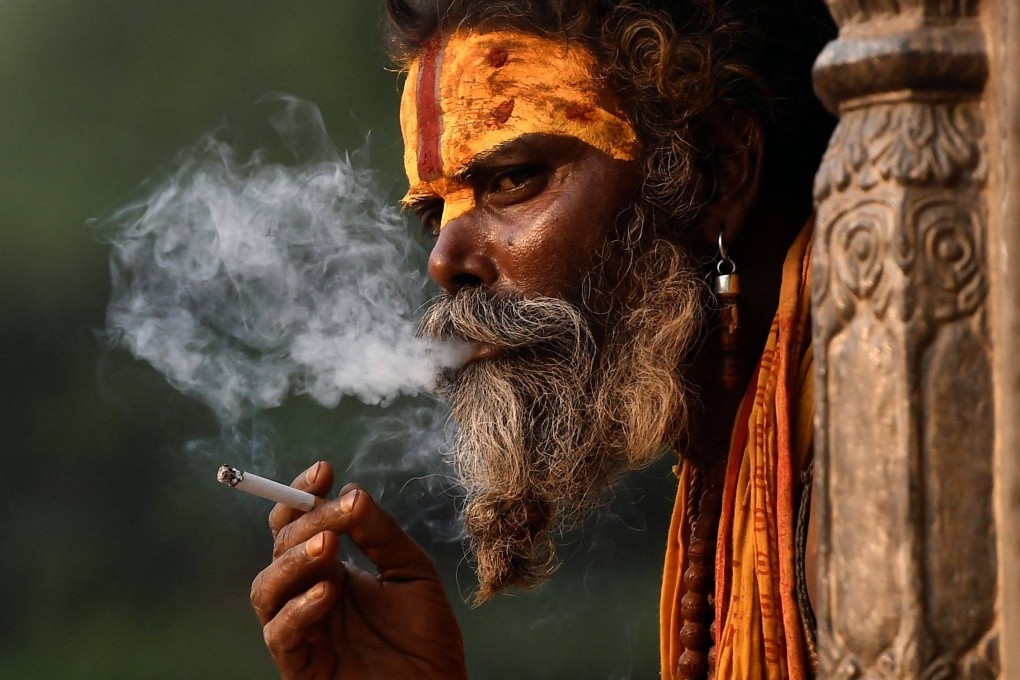 A Sadhu, or Hindu holy man, smokes a cigarette at a temple in Nepal’s capital of Kathmandu on Wednesday. Photo: AFP