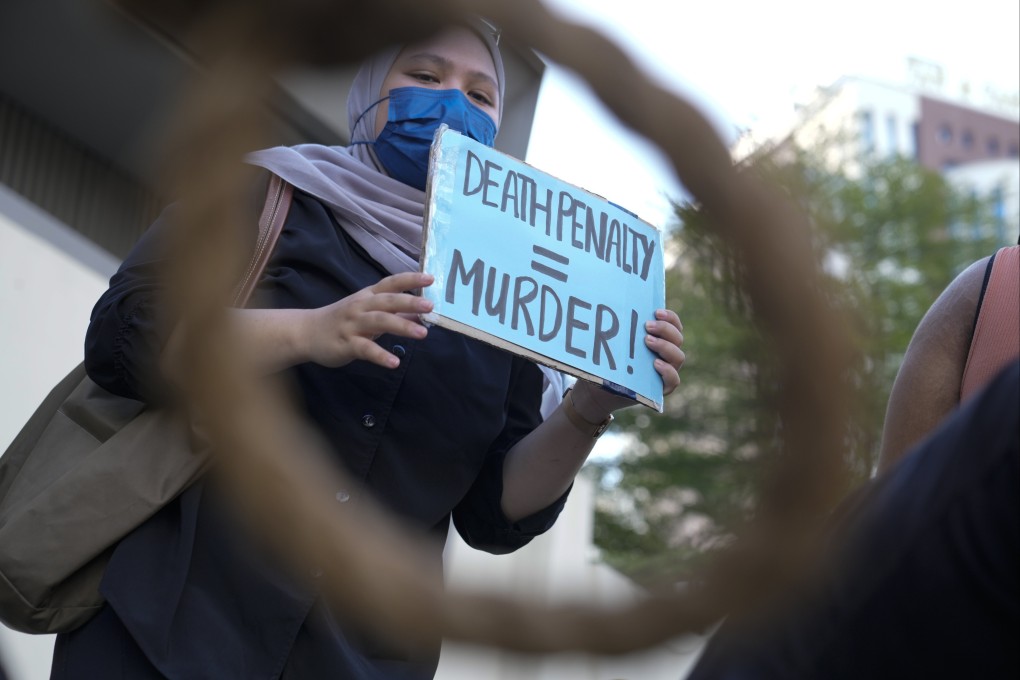 An activist holds a sign against the impending execution of a Malaysian man in Singapore. Photo: AP