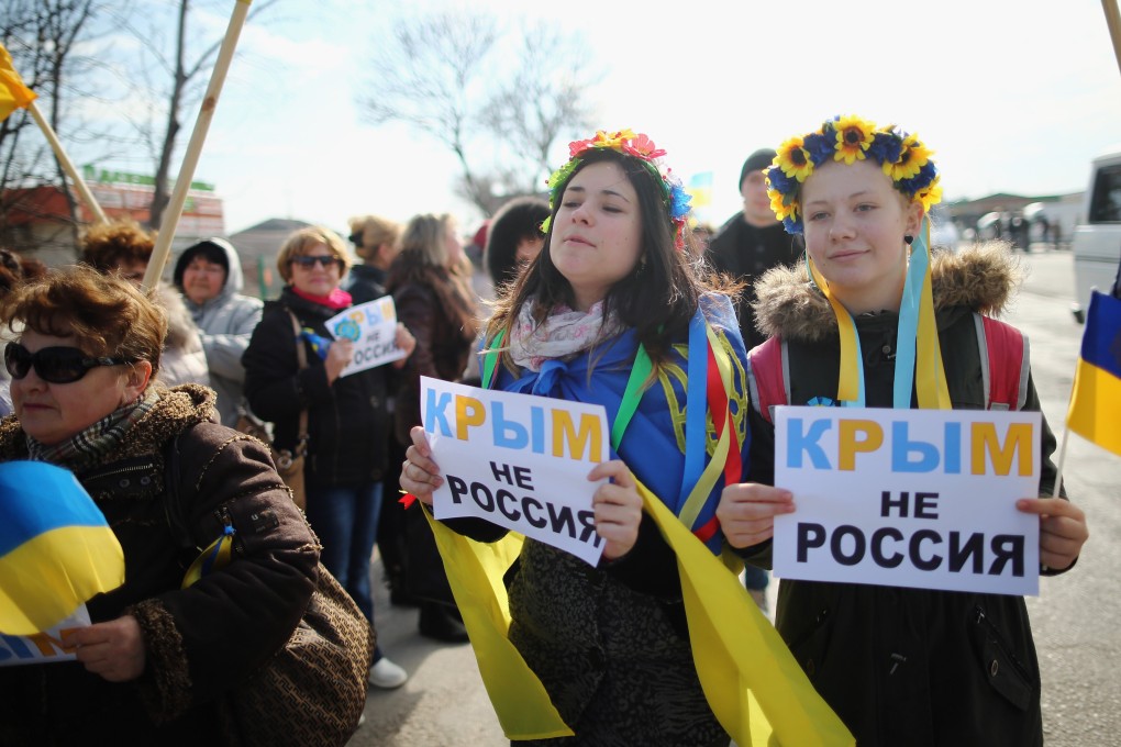 Two young Ukrainian women hold signs that read “Ukraine not Russia” in Crimea in 2014 after the territory’s annexation by Russian forces. Photo: Getty Images