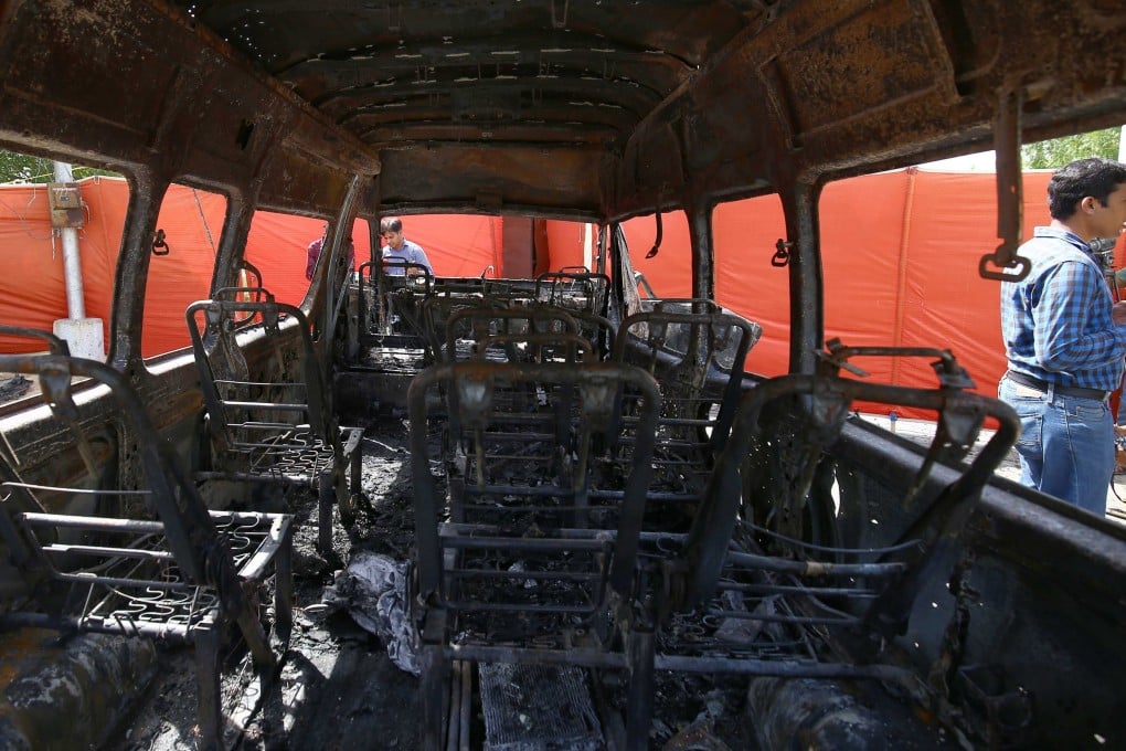 Security officials guard a damaged vehicle that was hit by a suicide bomber targeting Chinese nationals in Karachi, Pakistan, on April 27. The attack at the University of Karachi killed four people, including three Chinese nationals. Photo: EPA-EFE