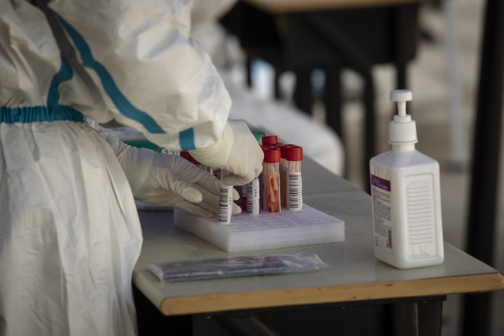 A worked filled tubes with batches of swabs during a round of Covid-19 testing in Shanghai on April 27, 2022. Photo: Bloomberg