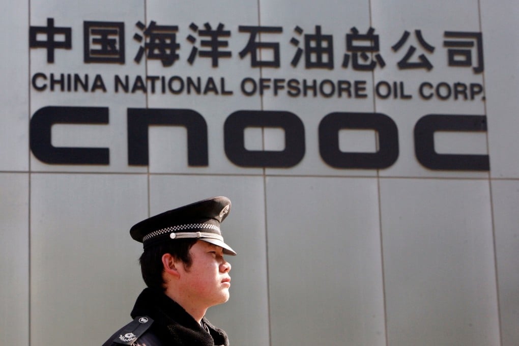 A security officer keeps watch outside the headquarters of China’s top offshore oil producer in Beijing. Photo: Reuters