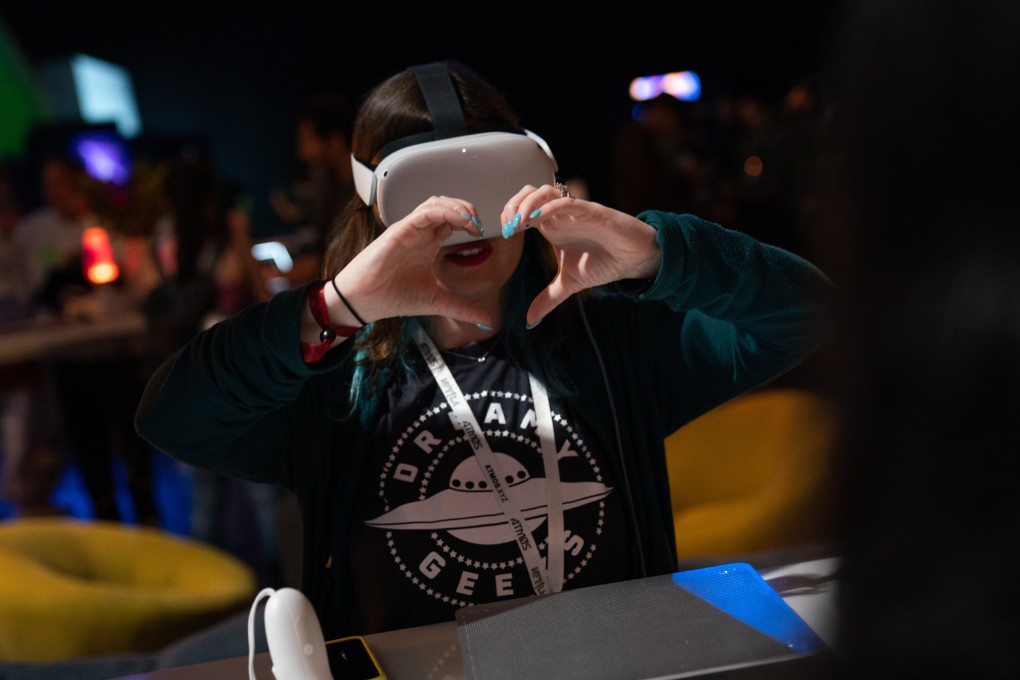 An exhibitor makes a heart shape while wearing a Meta Oculus Quest 2 virtual reality headset at the NFT LA conference in Los Angeles on March 30. Photo: Bloomberg