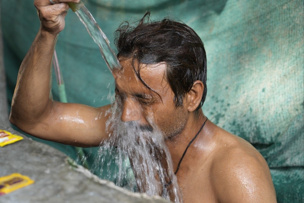 A man cools off under a public water tap in Lucknow, Uttar Pradesh, on Thursday as a severe heat wave sweeps the country. Photo: AP