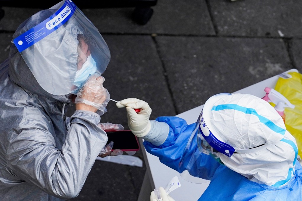 A worker in a protective suit collects a swab sample from a resident at a Covid-19 testing site in Shanghai. Photo: Reuters