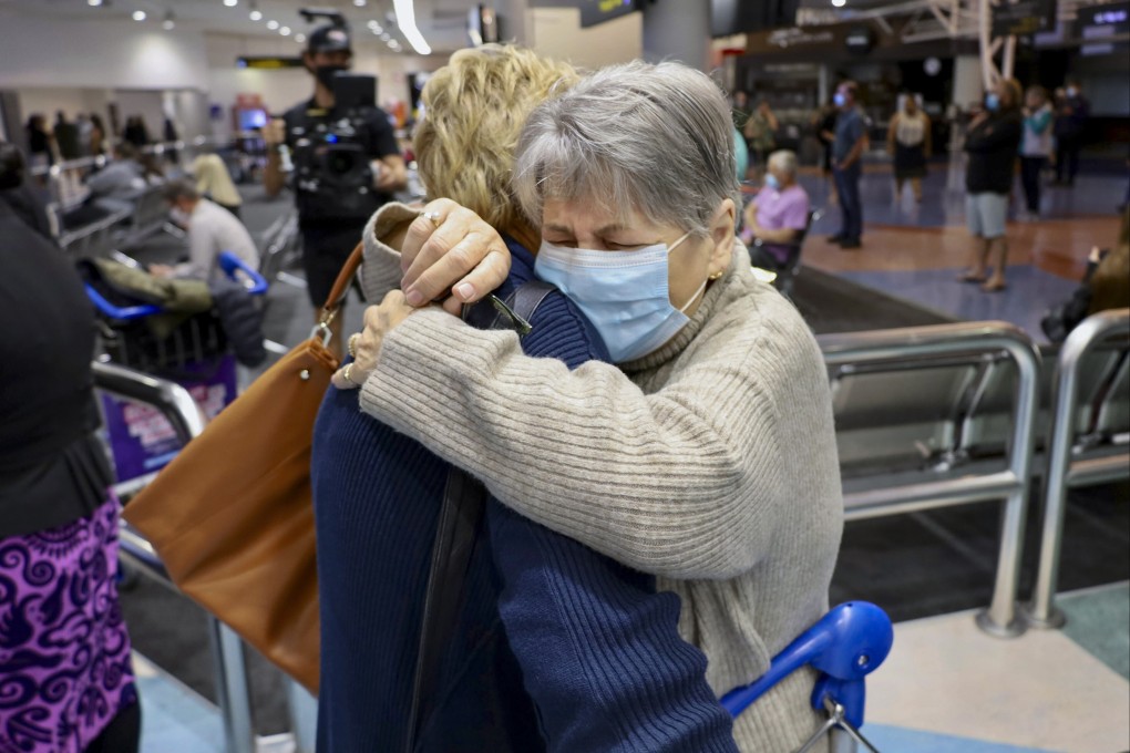 A passenger who took a flight from Los Angeles embraces a family member after arriving at Auckland International Airport on Monday. Photo: Jed Bradley/New Zealand Herald via AP