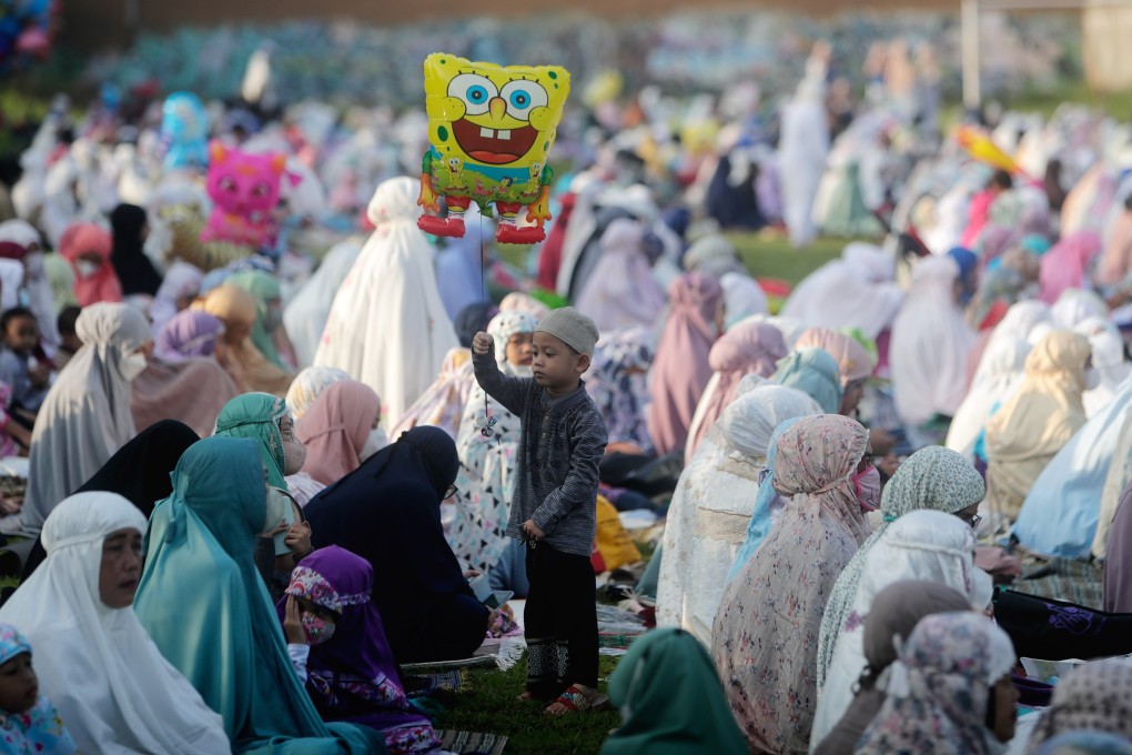 Children play during Eid al-Fitr prayers at a field in Depok, Indonesia, on Monday. Muslims around the world are celebrating the three-day festival marking the end of the holy fasting month of Ramadan. Photo: EPA-EFE