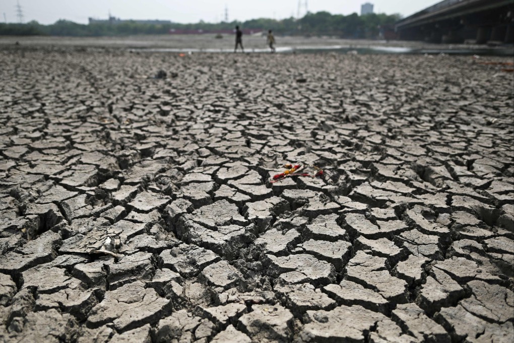 People walk across the parched Yamuna river bed in New Delhi. Photo: AFP