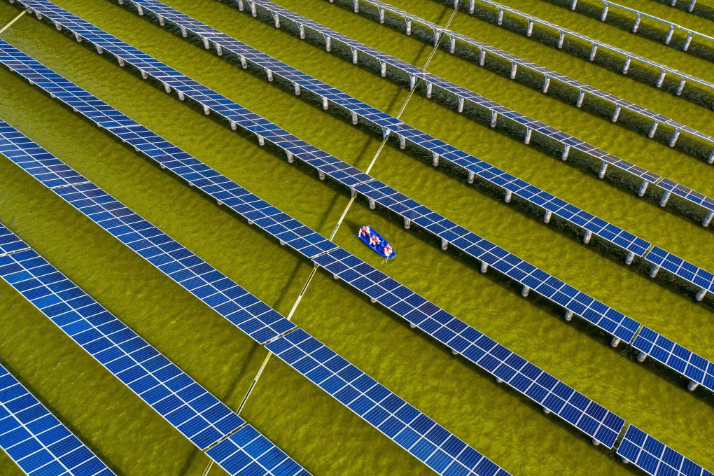 Electrical workers in a boat check solar panels at a photovoltaic power station built in a fishpond in Haian in China’s eastern Jiangsu province in 2021. Photo: AFP