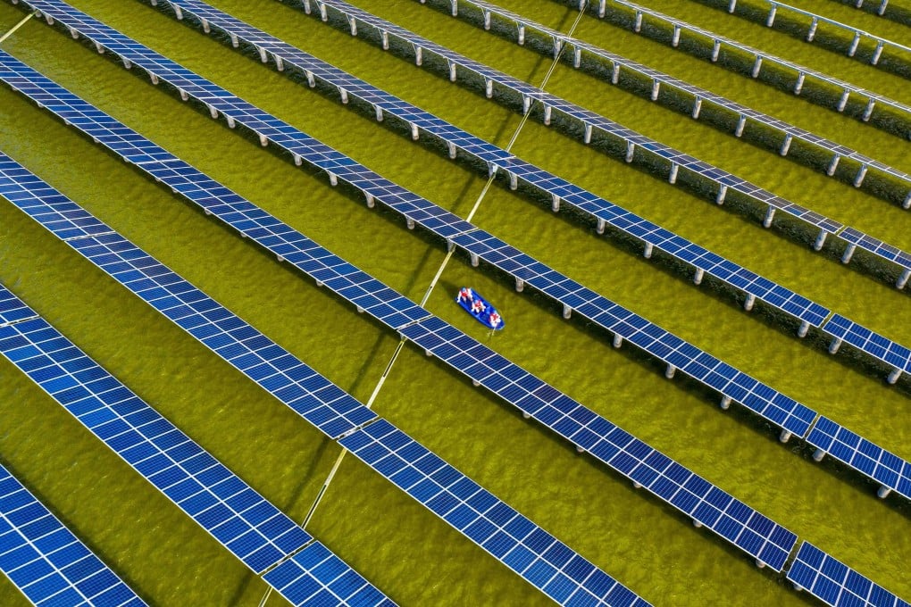 Electrical workers in a boat check solar panels at a photovoltaic power station built in a fishpond in Haian in China’s eastern Jiangsu province in 2021. Photo: AFP