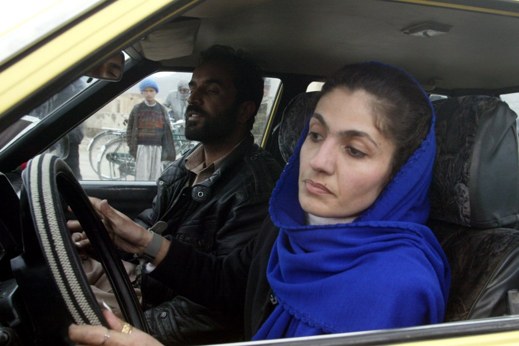 An Afghan woman drives with an instructor during a driving test in Kabul in 2003. Photo: Reuters