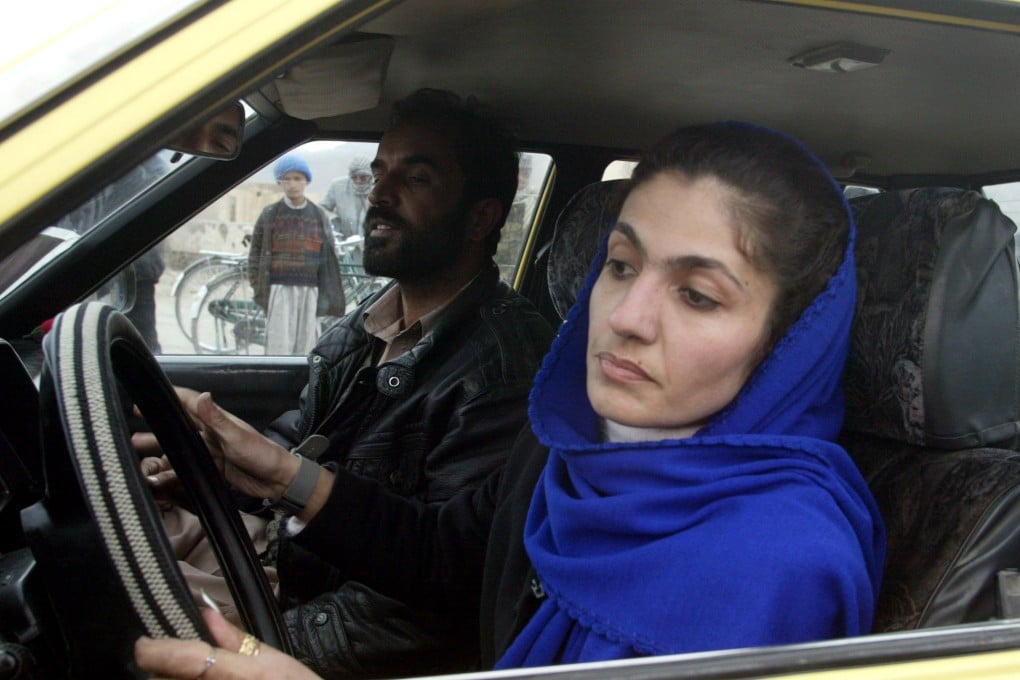 An Afghan woman drives with an instructor during a driving test in Kabul in 2003. Photo: Reuters