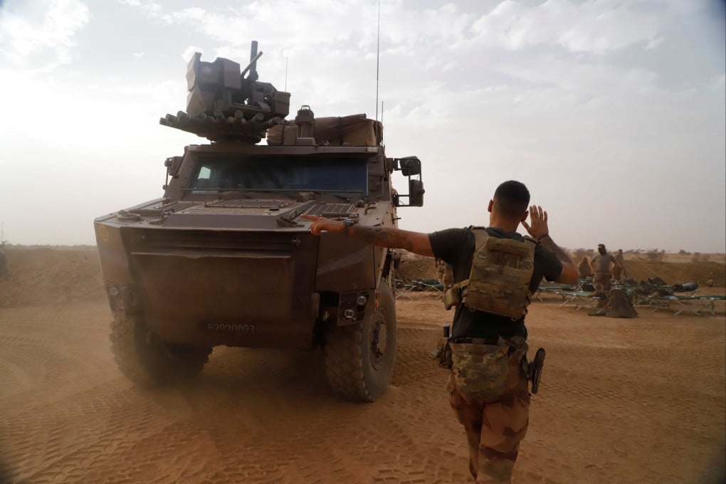 A soldier guides an armoured vehicle as French troops leave Gossi, Mali in April. Photo: Reuters