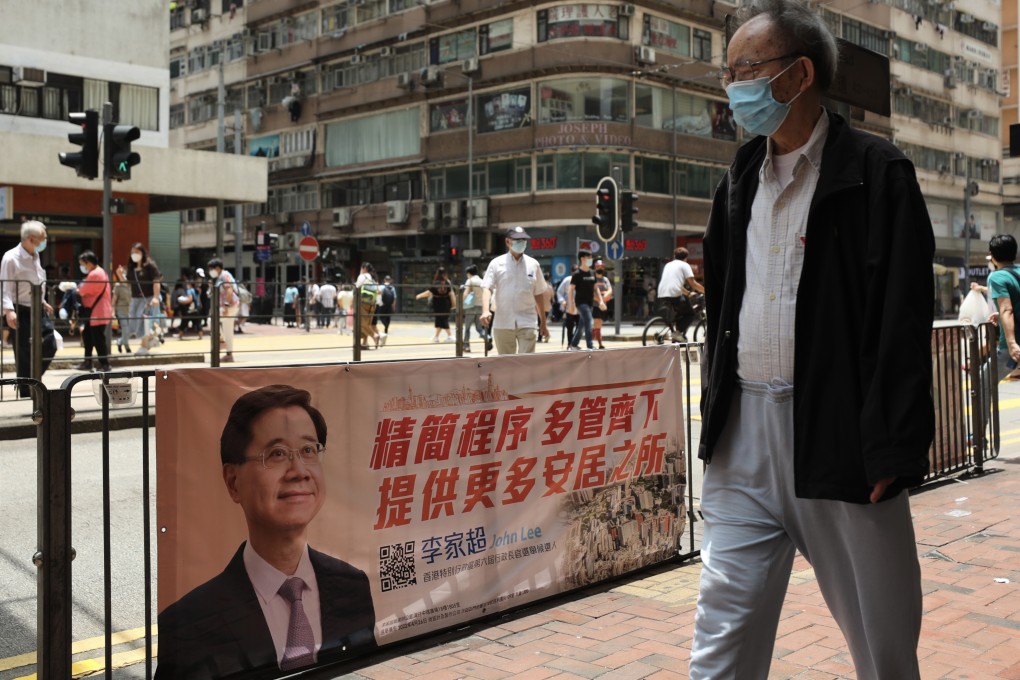 A man passes a campaign poster for chief executive candidate John Lee in North Point on April 29. Photo: Xiaomei Chen