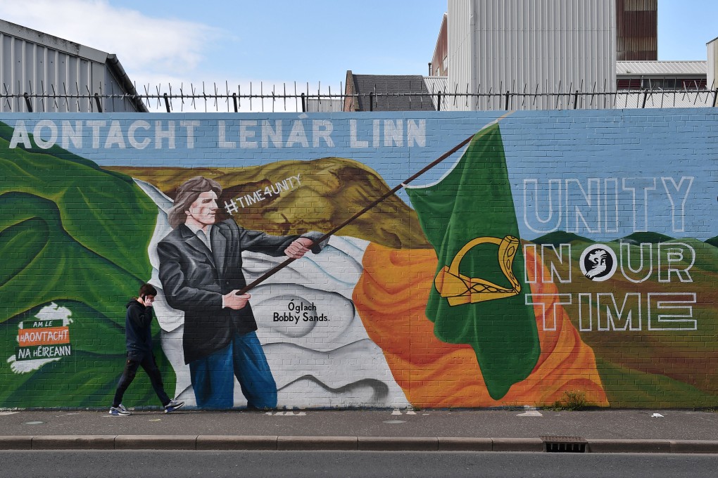 A man walks past a Sinn Fein mural calling for Irish unity in Belfast, Northern Ireland in April. Photo: TNS