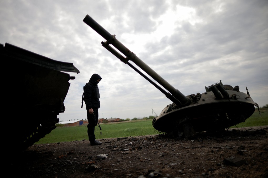 A Ukrainian service member inspects a destroyed Russian Armoured Personnel Carrier in the Zaporizhzhia region, Ukraine. Photo: Reuters