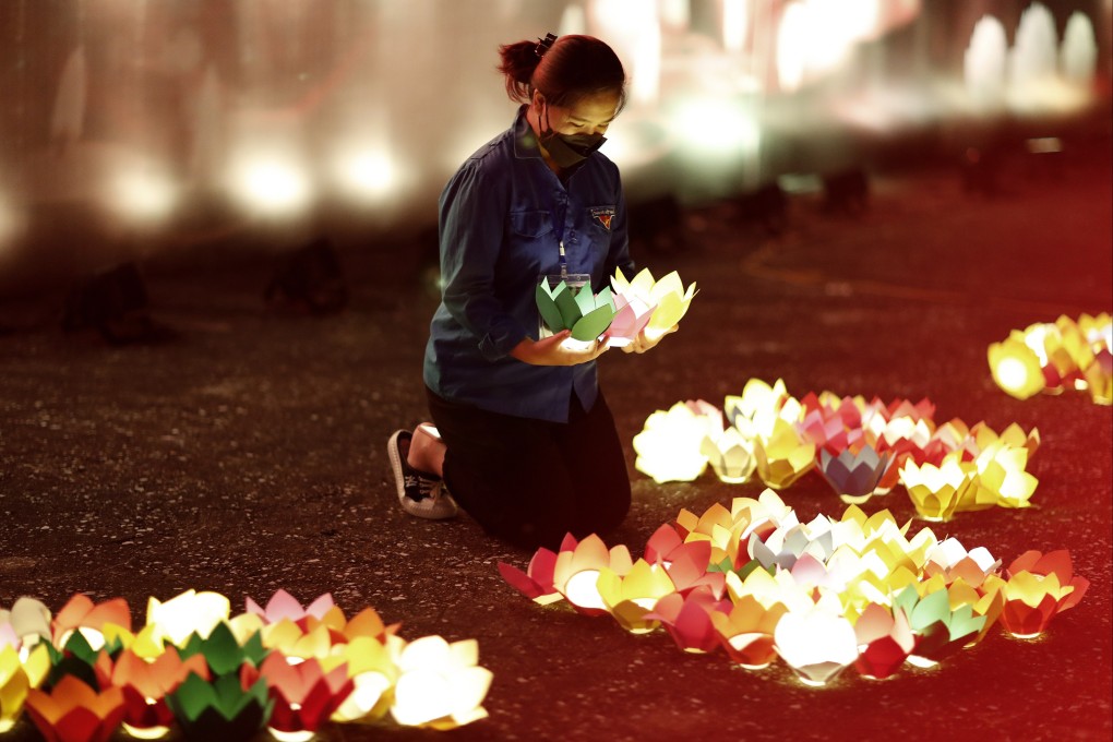 A girl places paper lights at a memorial for victims of the coronavirus pandemic, in Hanoi, Vietnam, on November 19, 2021. Photo: EPA-EFE
