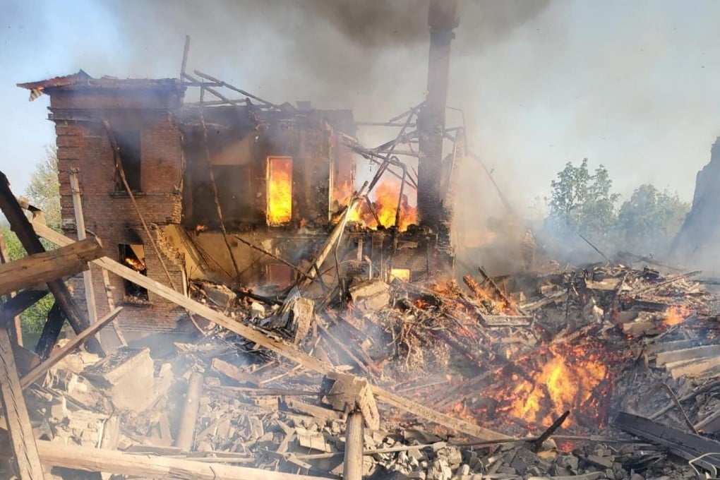 Emergency crew help a man stuck in debris, after a school building was hit as a result of shelling, in the village of Bilohorivka, Luhansk, Ukraine on Sunday. Photo: State Emergency Services/Handout via Reuters