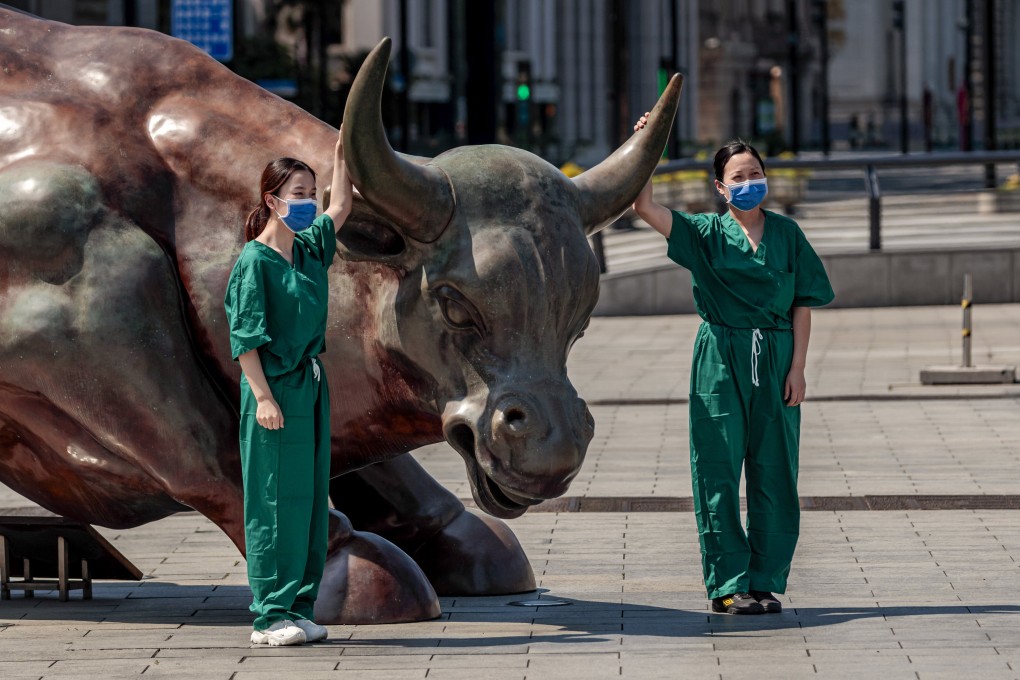 Healthcare volunteers pose for a picture on a deserted street amid the ongoing Covid-19 lockdown in Shanghai. The lockdown is affecting the economy and the stock markets in the region. Photo: EPA-EFE