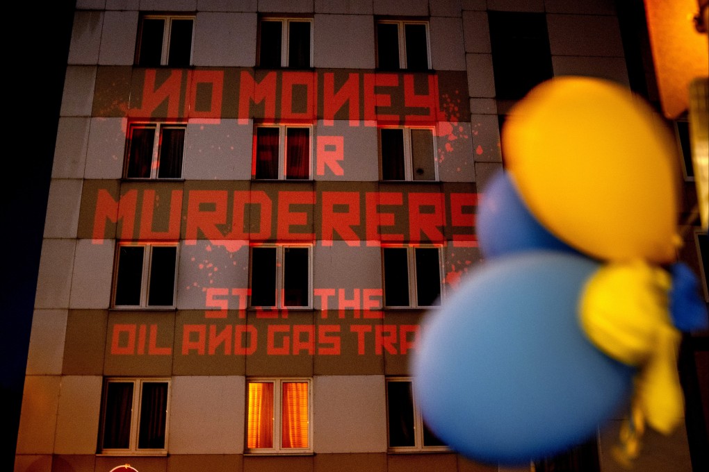 The words ‘No Money for Murderers, Stop the Oil and Gas Trade’ projected by activists onto the Russian consulate in Frankfurt, Germany. Photo: AP