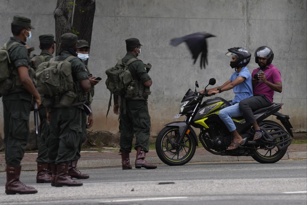 Sri Lankan soldiers stop a motorcyclist at a checkpoint in Colombo on Tuesday amid a nationwide curfew following Monday’s unrest. Photo: AP