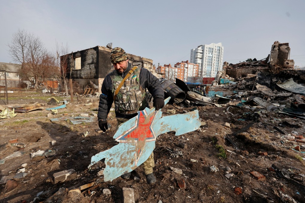 A member of the Ukrainian Territorial Defence Forces holds a part of a Russian Sukhoi Su-34 fighting aircraft in Chernihiv in April. Photo: Reuters