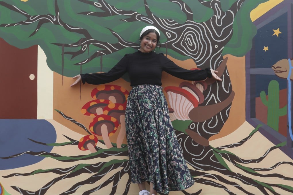 Ahmad Rida Nisar with her mural, outside the AIA Vitality Park at Central Pier. She is one of five young artists taking part in a youth mentorship programme organised by HKwalls. Photo: Jonathan Wong